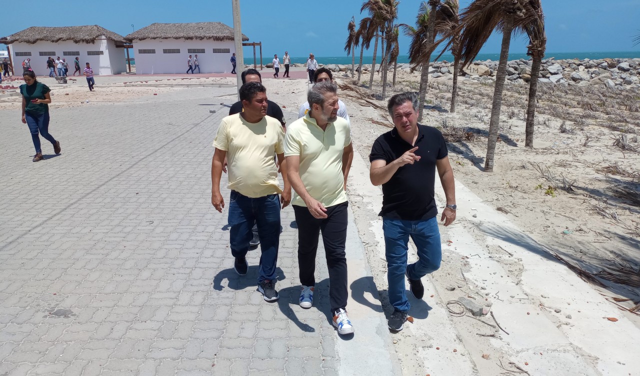 grupo de pessoas caminha pelo calçadão em construção na praia do Serviluz